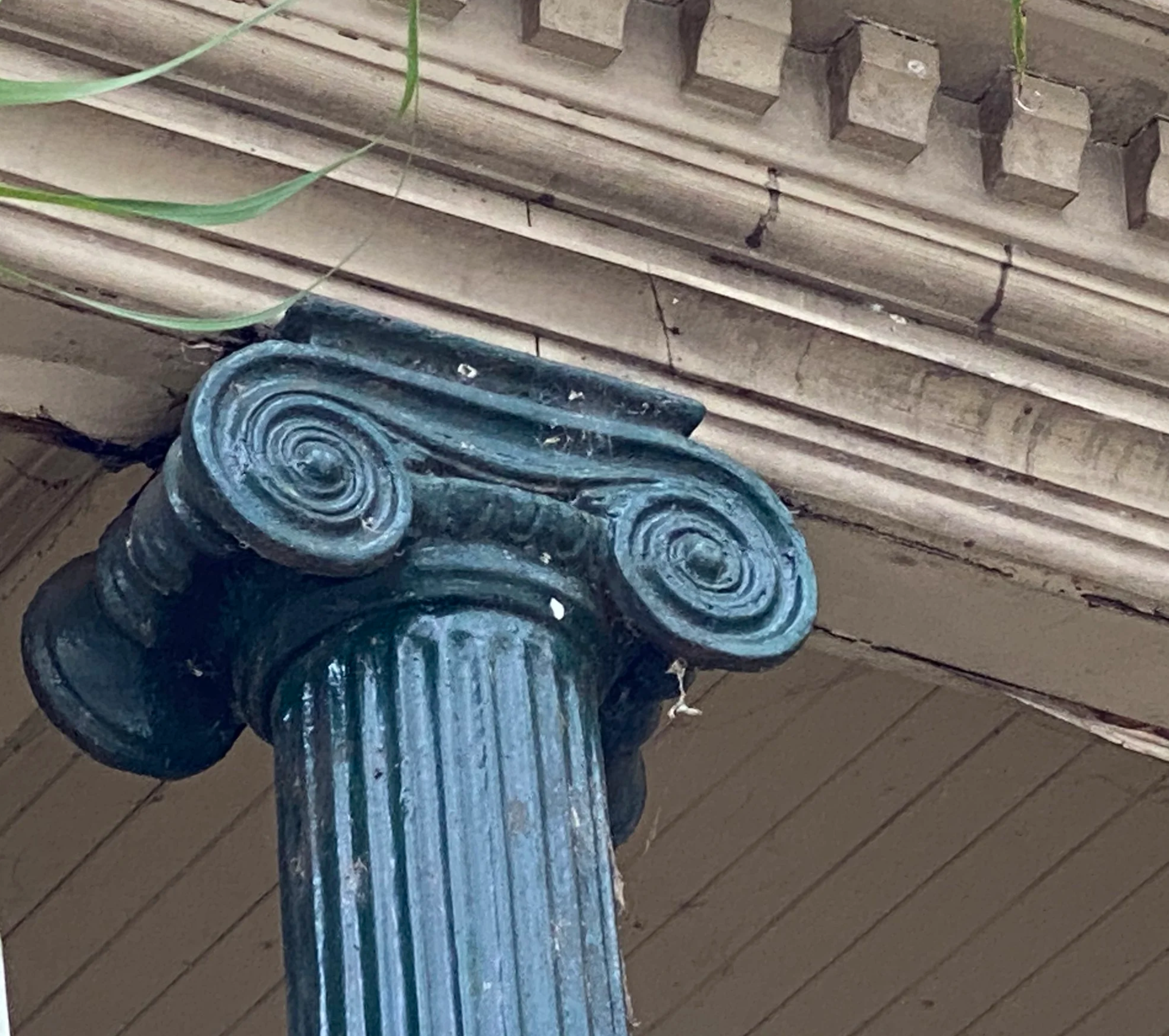 Close-up of a decorative fountain with multiple streams of blue water flowing from sculptures in an outdoor setting with wooden decking.