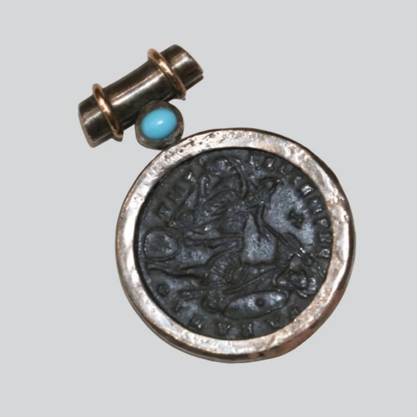 Close-up of a vintage coin with an engraved profile of a person and the text 'D G REG FD' around the edge, a small metallic object with a blue ball attached above the coin.