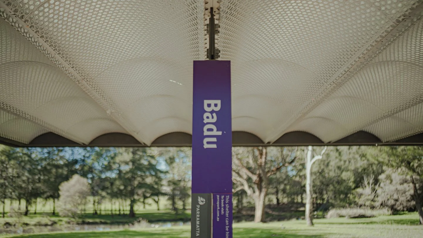 Close-up of a purple and black park shelter sign that says "Bad