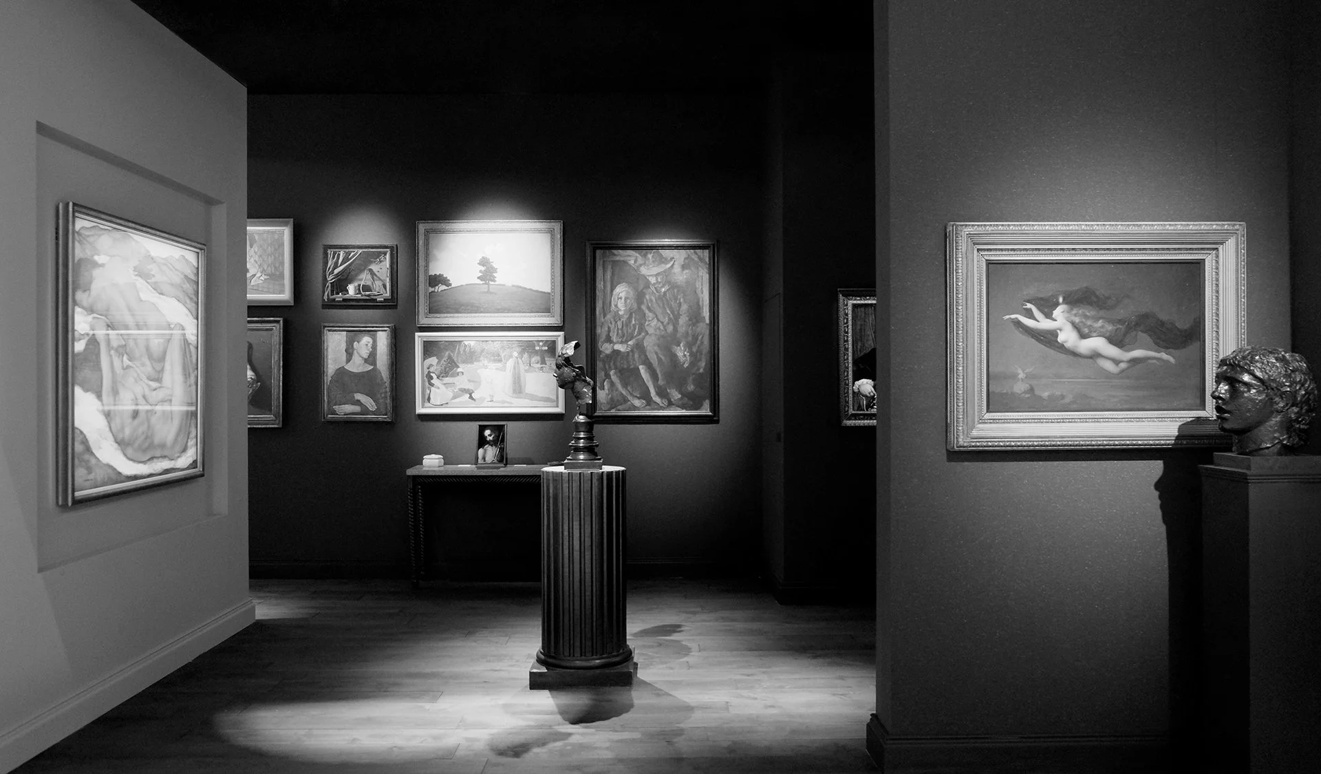Art fair gallery booth interior with paintings and sculpture displays.