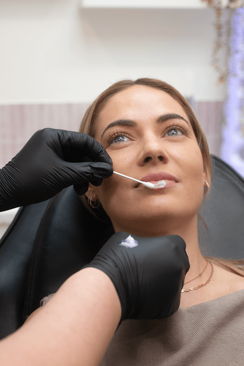 Woman receiving facial numbing treatment at define clinic