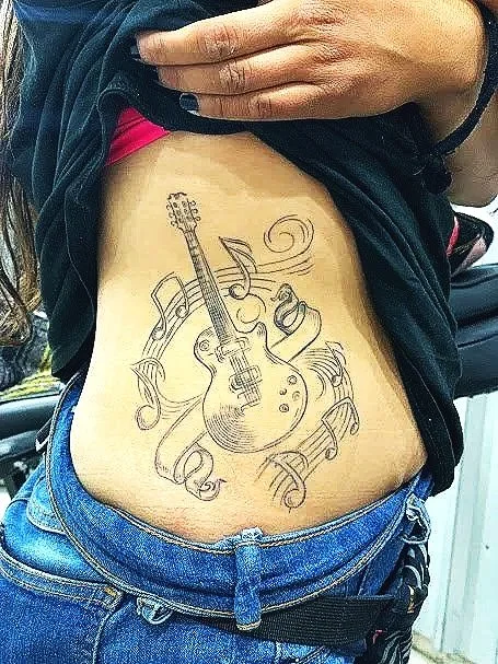 guitar tattoo by kidd in cabo san lucas with the best tattoo artist 