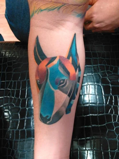 Colorful tattoo of a horse's head on a person's inner forearm.