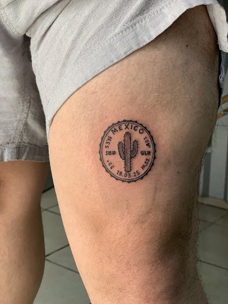 Tattoo of a cactus with text '7BR MEXICO 10th' and date '18.03.25' on a person's thigh.