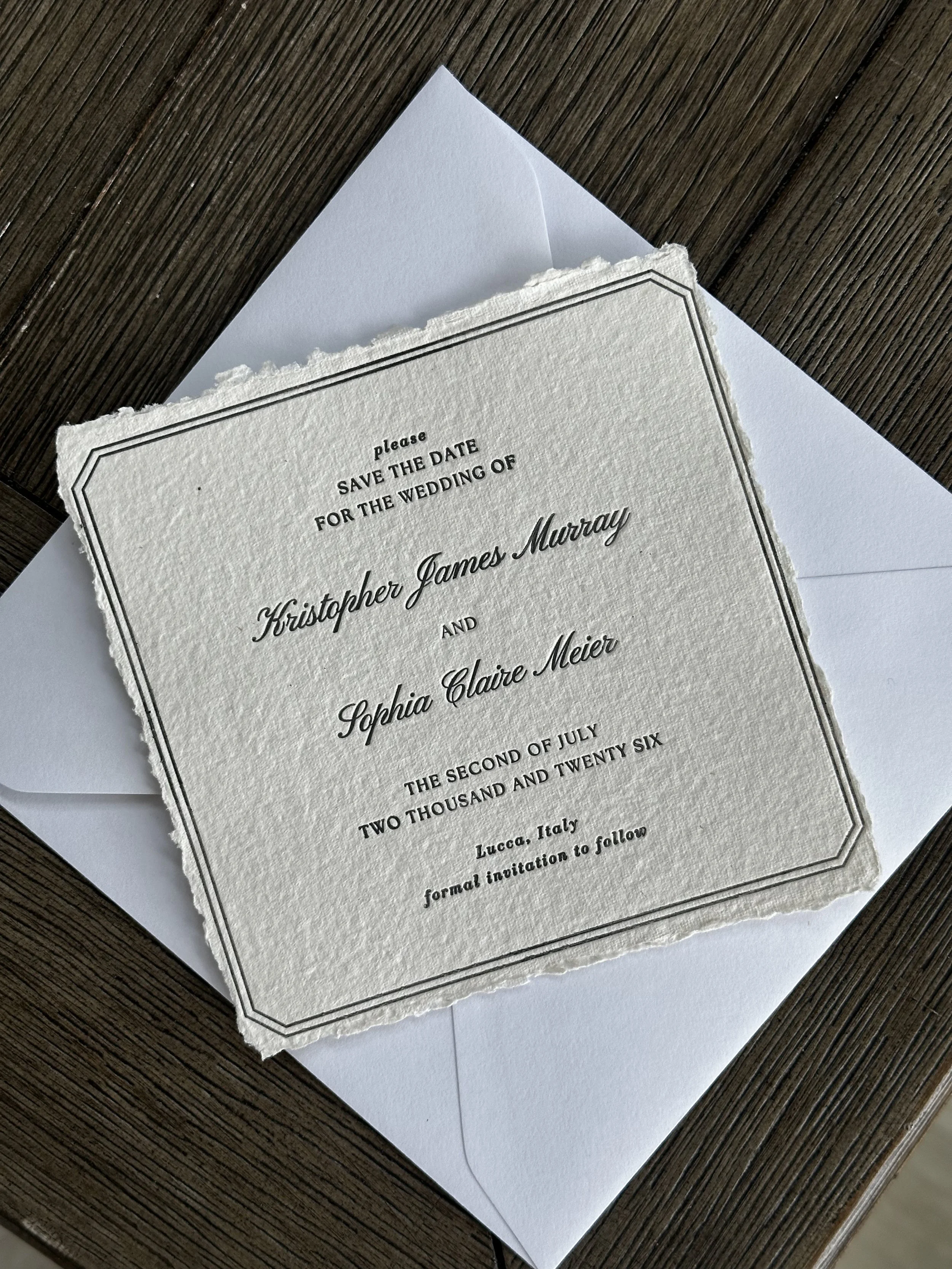 Wedding save the date invitation with torn edges, placed on a white envelope.