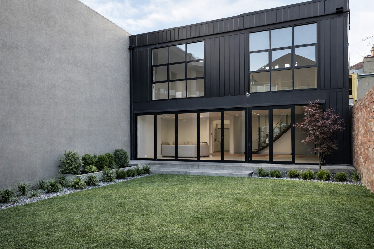 Modern Melbourne house extension and renovation by Box Domus featuring a sleek black facade, full-height glazing and landscaped rear garden.