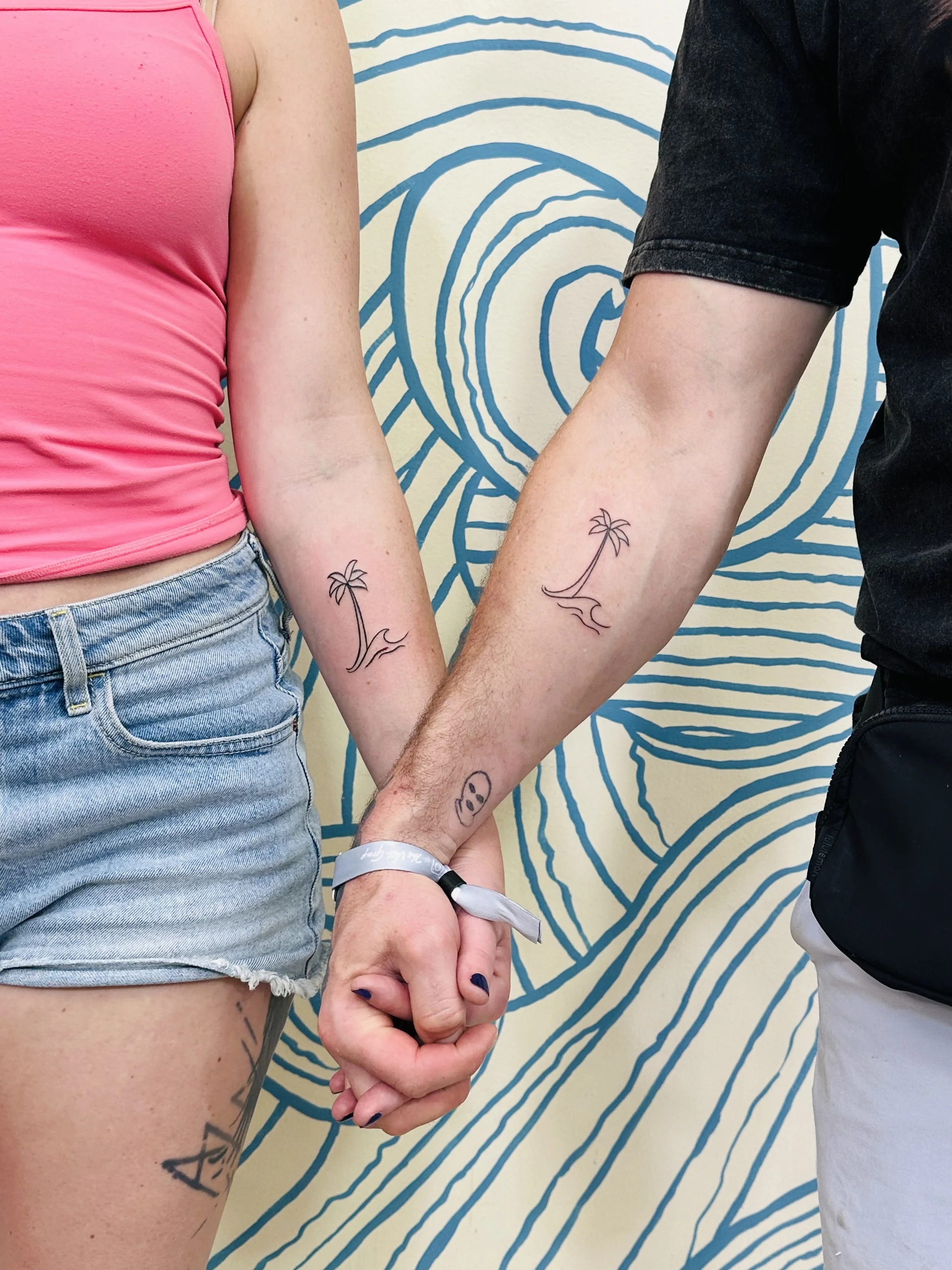 Couples matching tattoo of a palm tree at a Cabo San Lucas tattoo shop