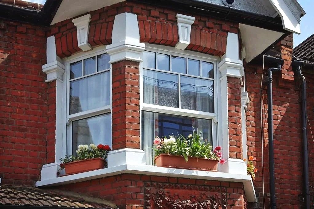 White sliding sash bay window installed in a red brick property in the West Midlands