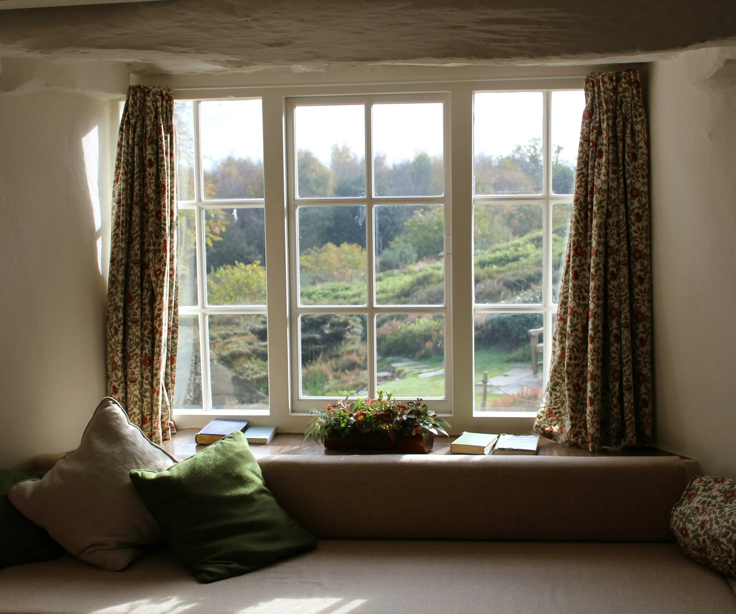 Traditional white framed window with built-in seat and garden views in West Midlands home