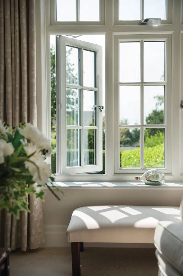White uPVC casement window open inside a bright living room overlooking a garden in a West Midlands home