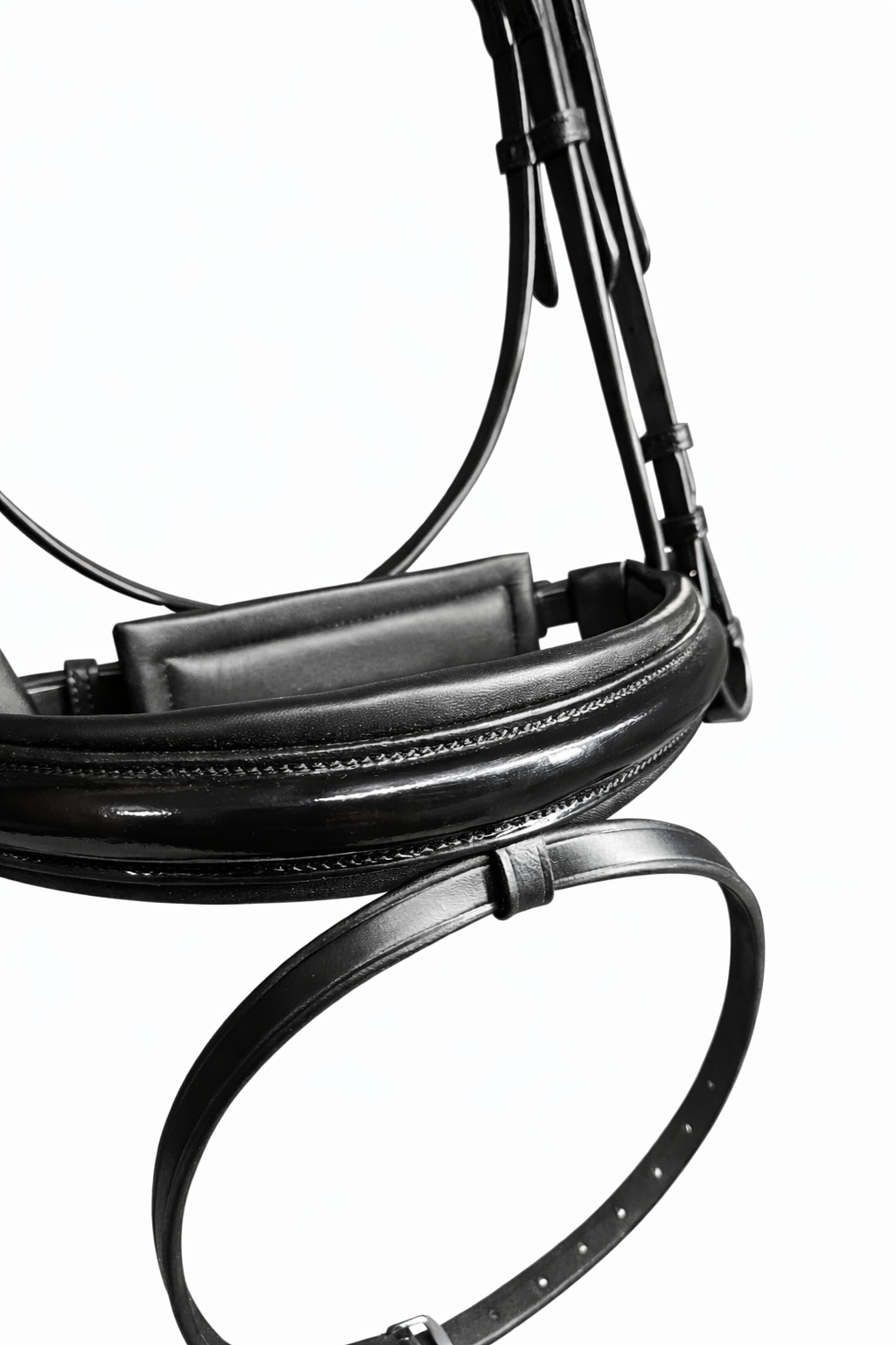 Close-up of a black leather horse bridle noseband with patent leather