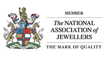 A logo for the National Association of Jewellers featuring a crest with a gold lion, two unicorns, shields, and flags, alongside text that reads: 'MEMBER, The NATIONAL ASSOCIATION of JEWELLERS, THE MARK OF QUALITY'.