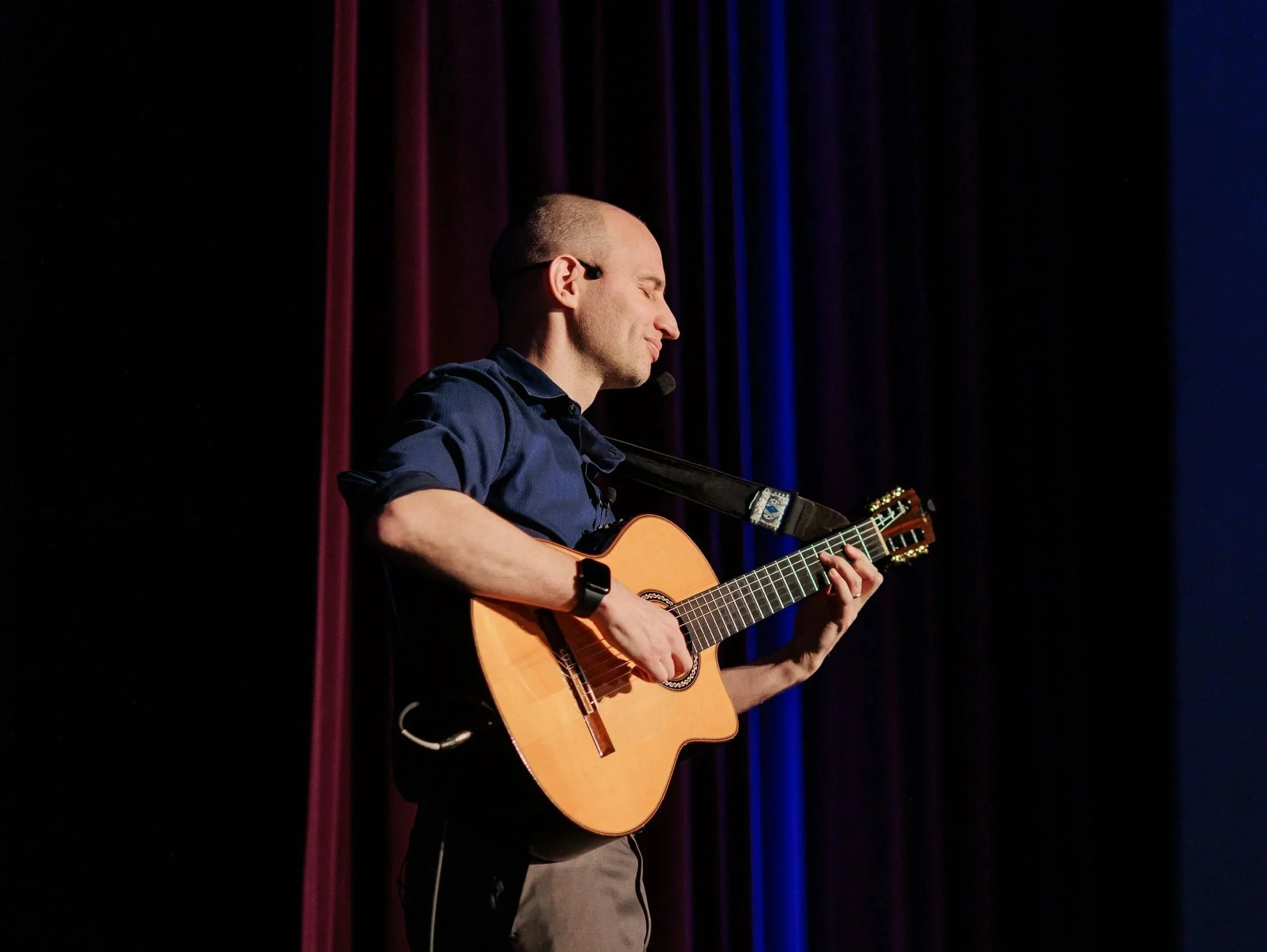 Jim Perona performing classical guitar at a live concert