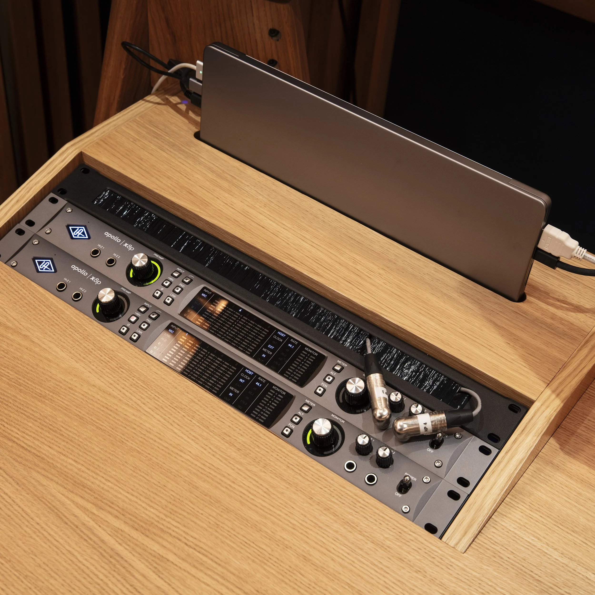 Table de mixage audio et ordinateur portable sur un bureau en bois.