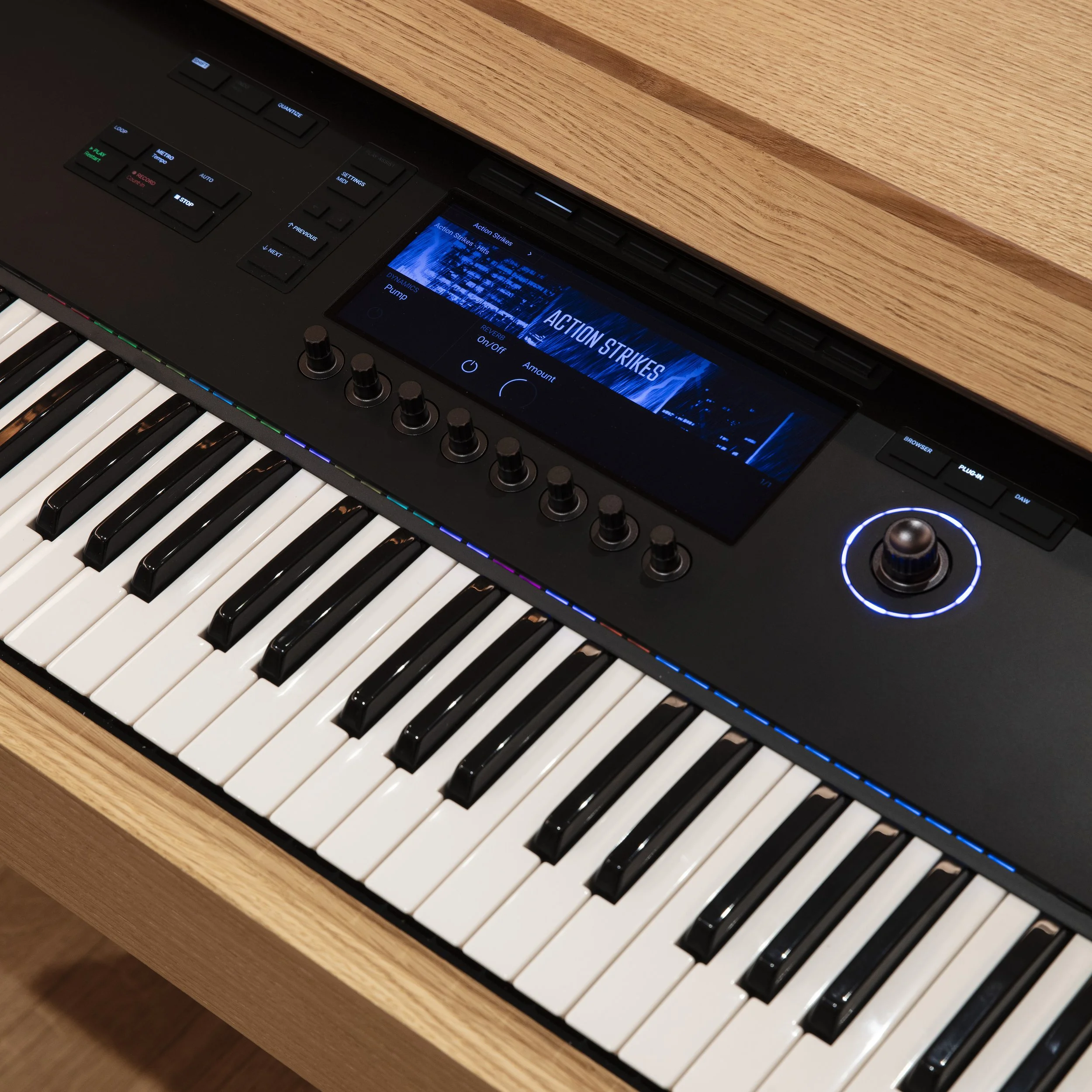 Clavier numérique noir avec un écran LCD, commandes et boutons lumineux, placé sur un meuble en bois.