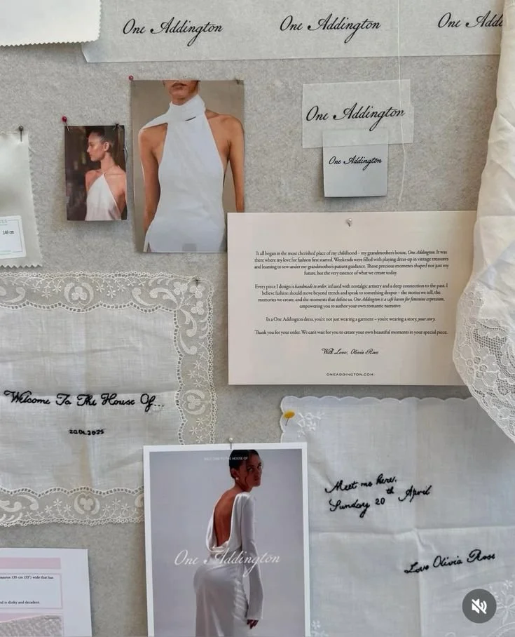 Wedding dress designer's mood board with fabric samples, photographs of models wearing elegant white dresses, handwritten notes, and a letter explaining the designer's inspiration.