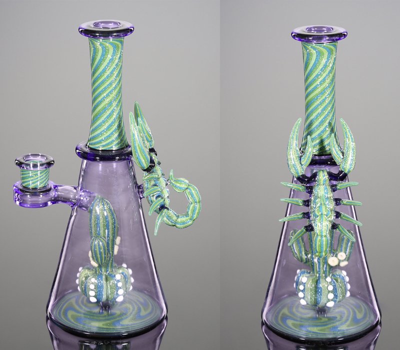 Colorful glass art piece representing a cactus growing on a laboratory flask with a long neck, leaf-like appendages, and decorative details.