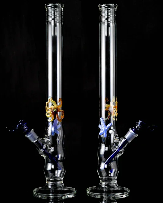 Two glass bongs with decorative flowers and starfish, positioned against a black background.