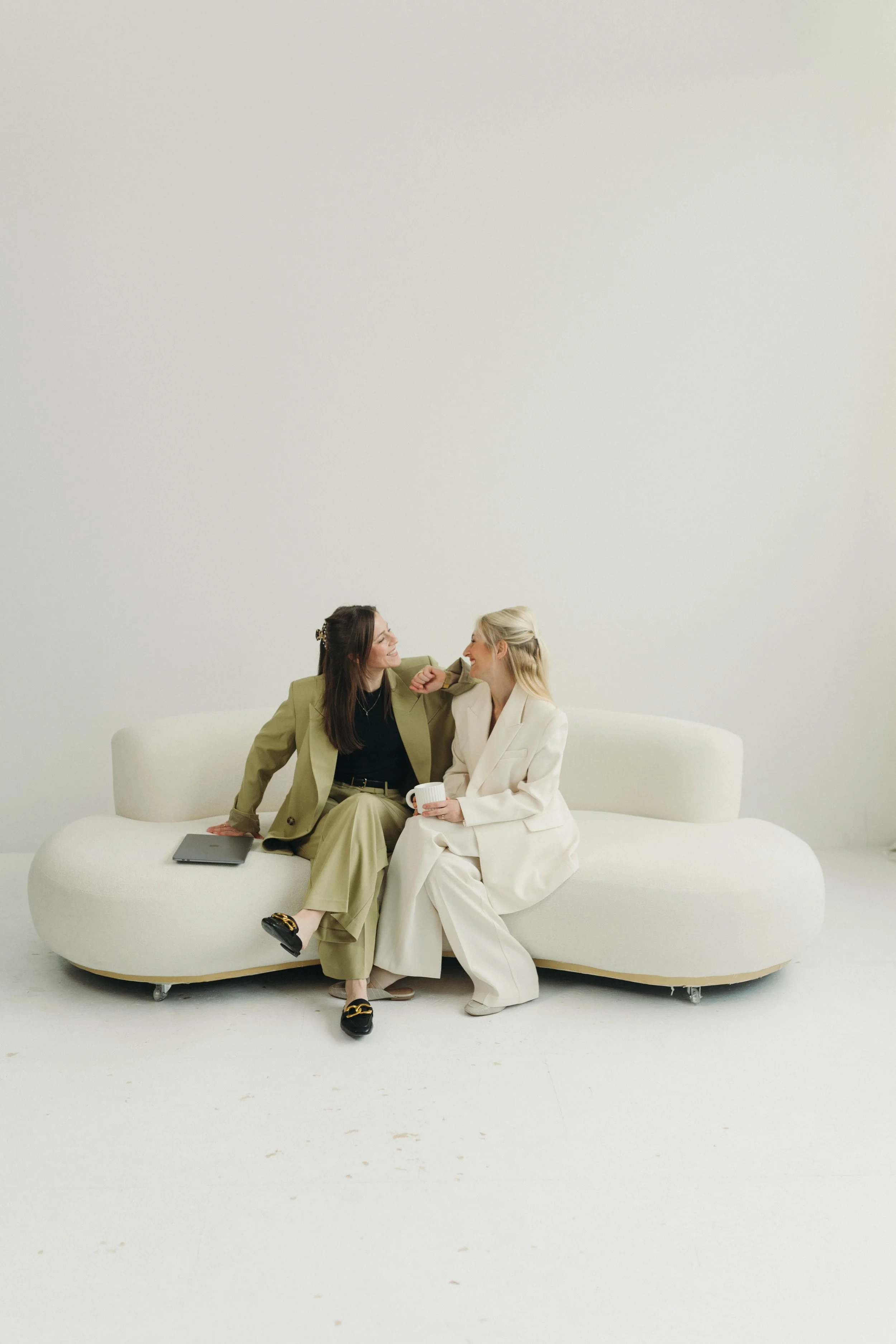 Wedding Planner Team von Two in Bloom auf hellem Sofa im modernen Studio