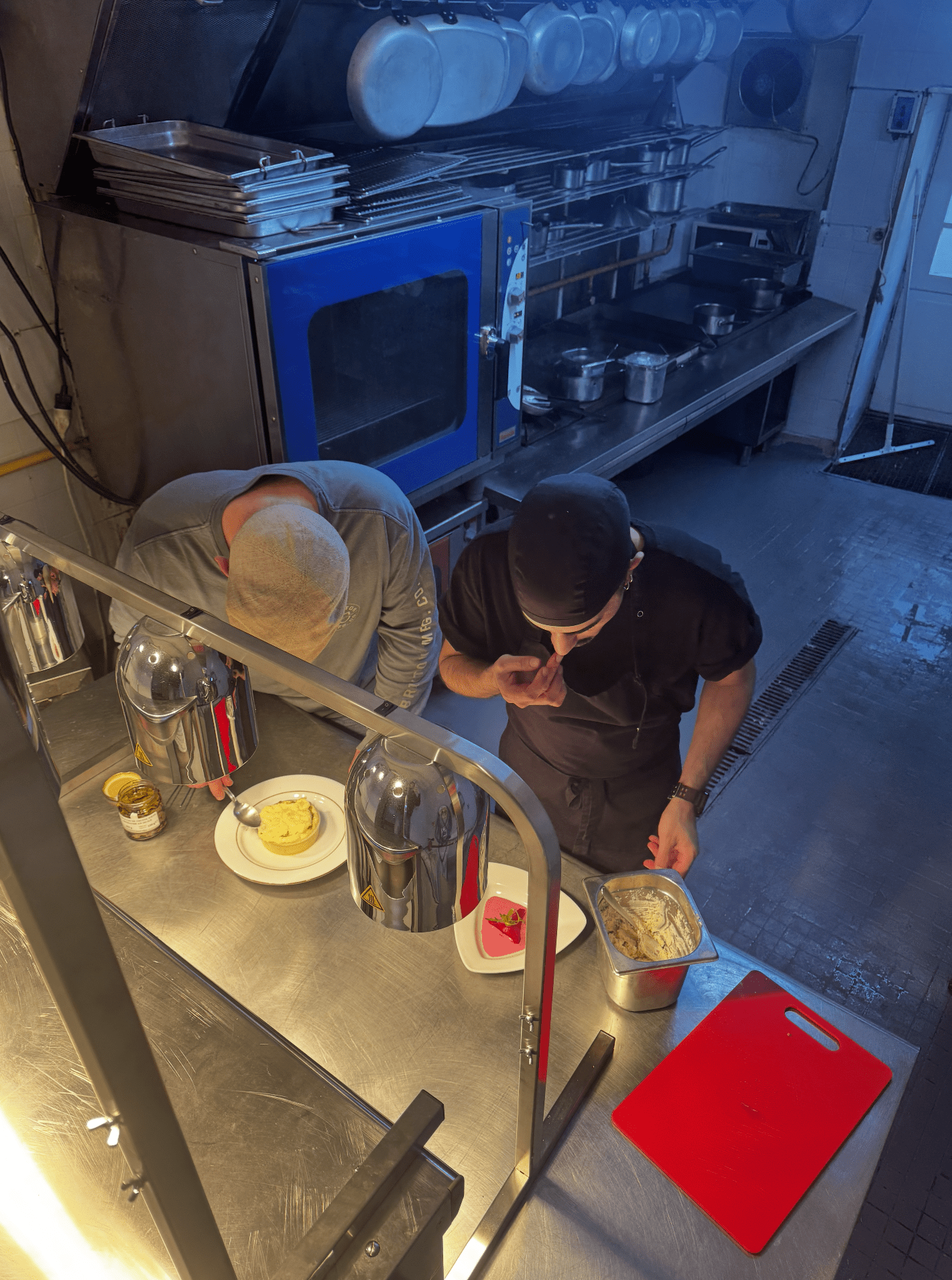 Deux cuisiniers dressant des plats dans les cuisines du restaurant.