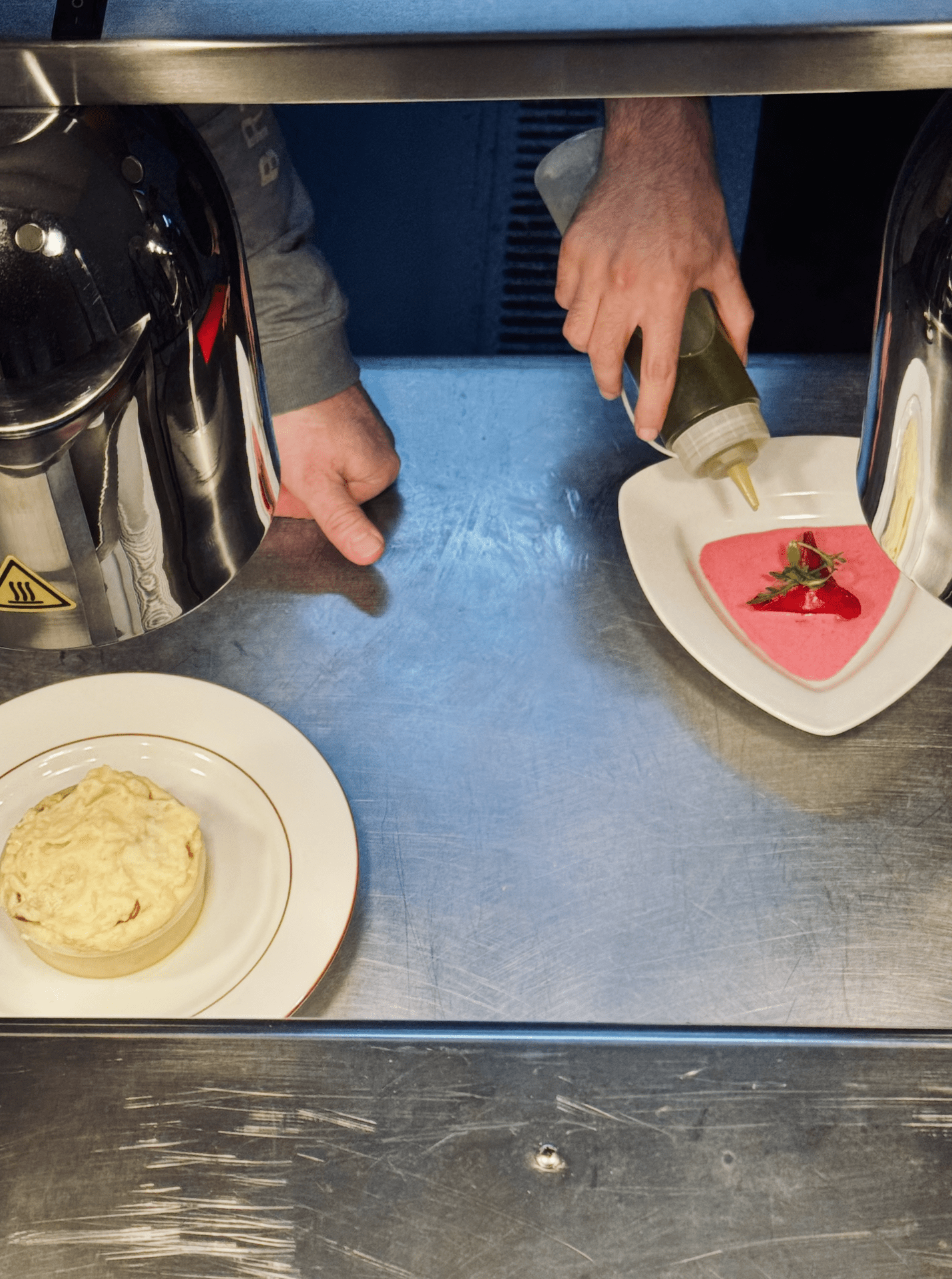 Dressage d'assiettes en cuisine avant envoi en salle.