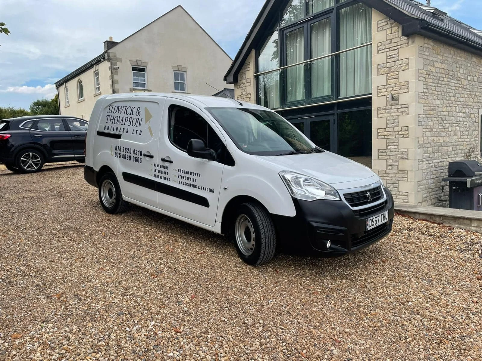 White company van parked on a gravel driveway in front of a modern house, with black text advertising Sidwick & Thompson Builders Ltd, including phone numbers and services like new builds, extensions, renovations, ground works, stone walls, landscapi