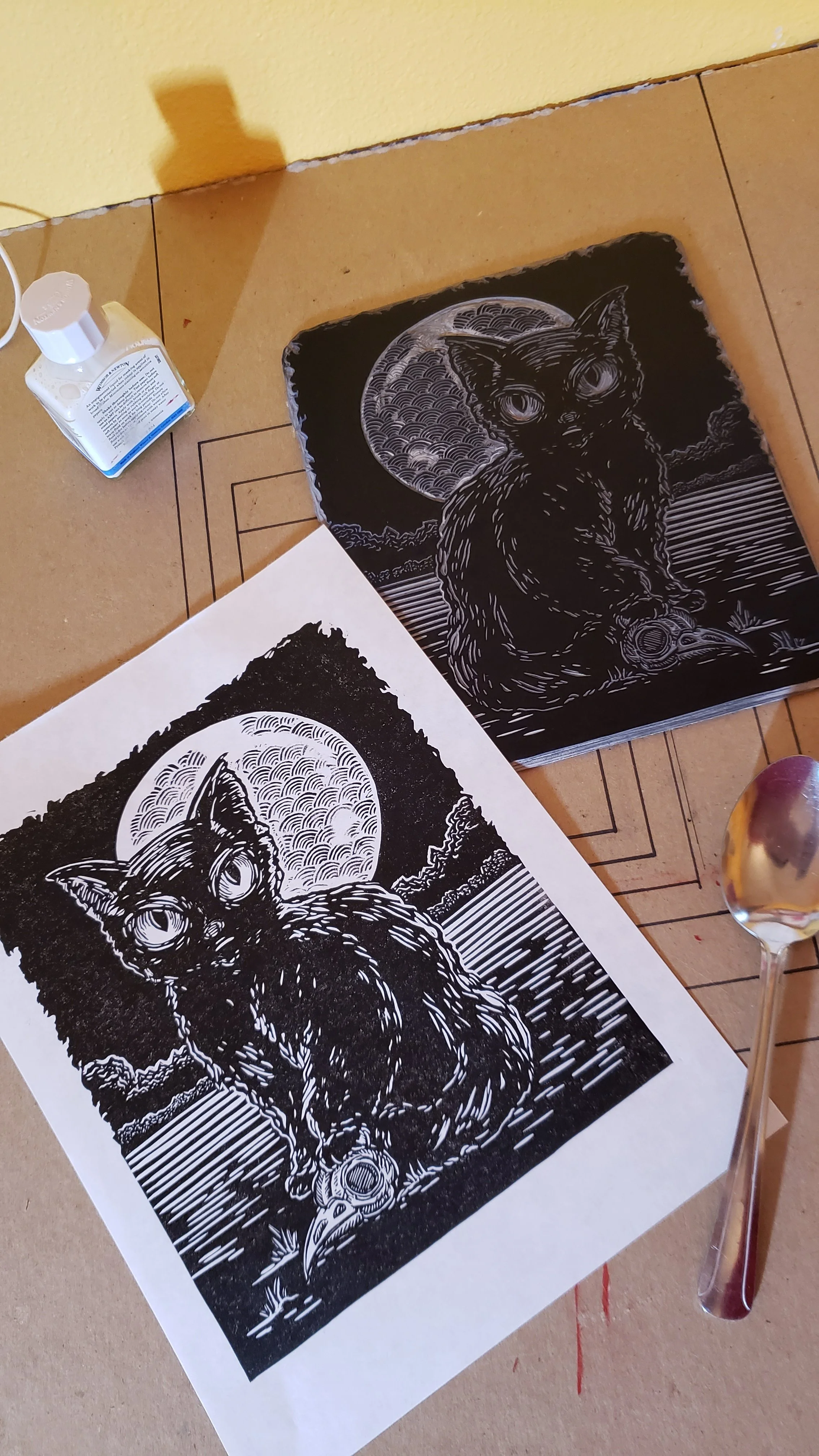 test print of bad kitty linocut fully inked block without ghost printing of moon portion, spoon was used for hand burnishing