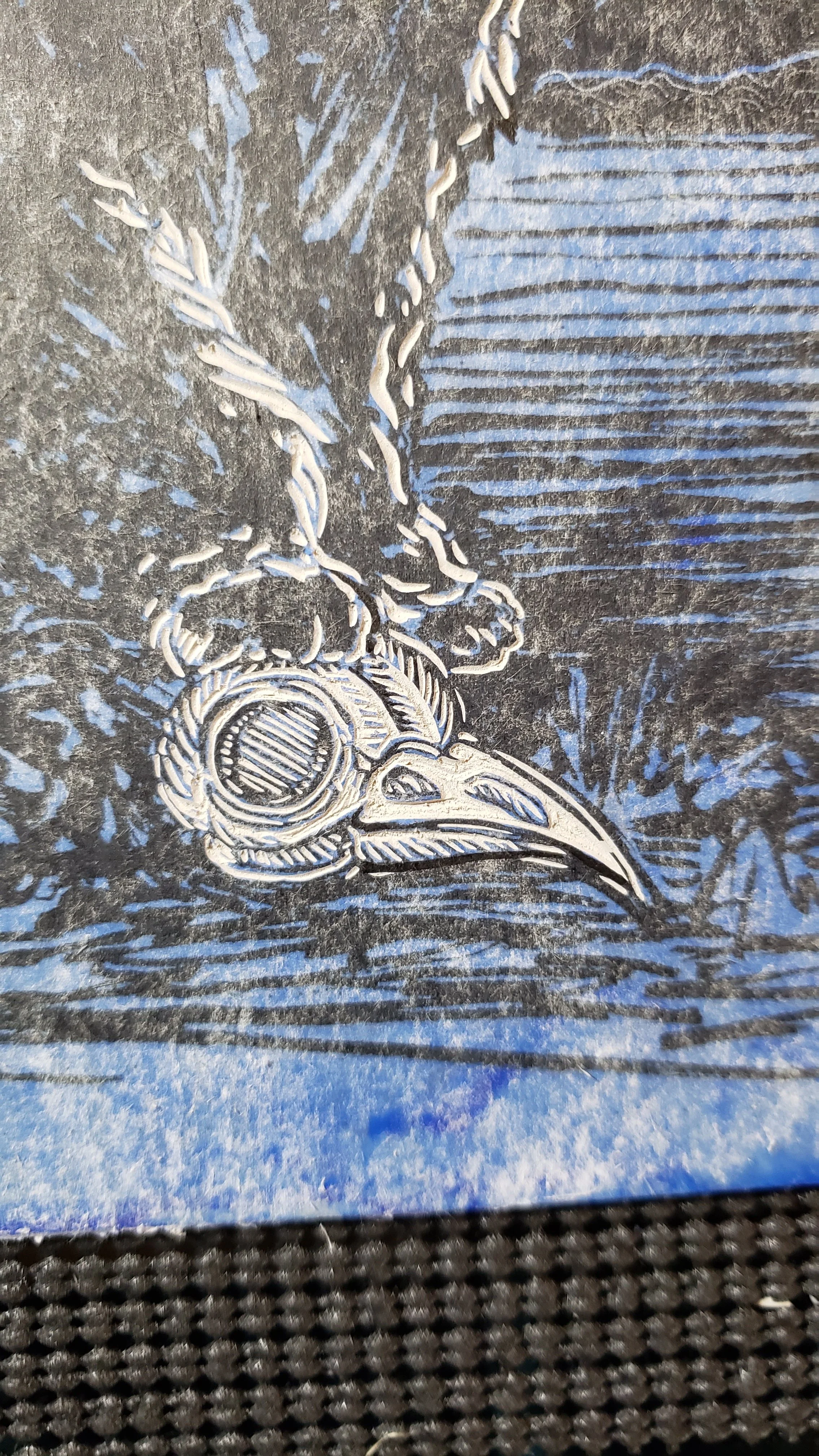 detail of bird skull on linocut block mid carving