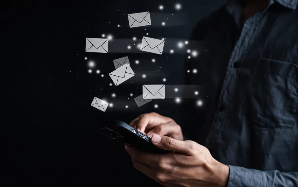 Email messages flying out of a phone into an organized inbox