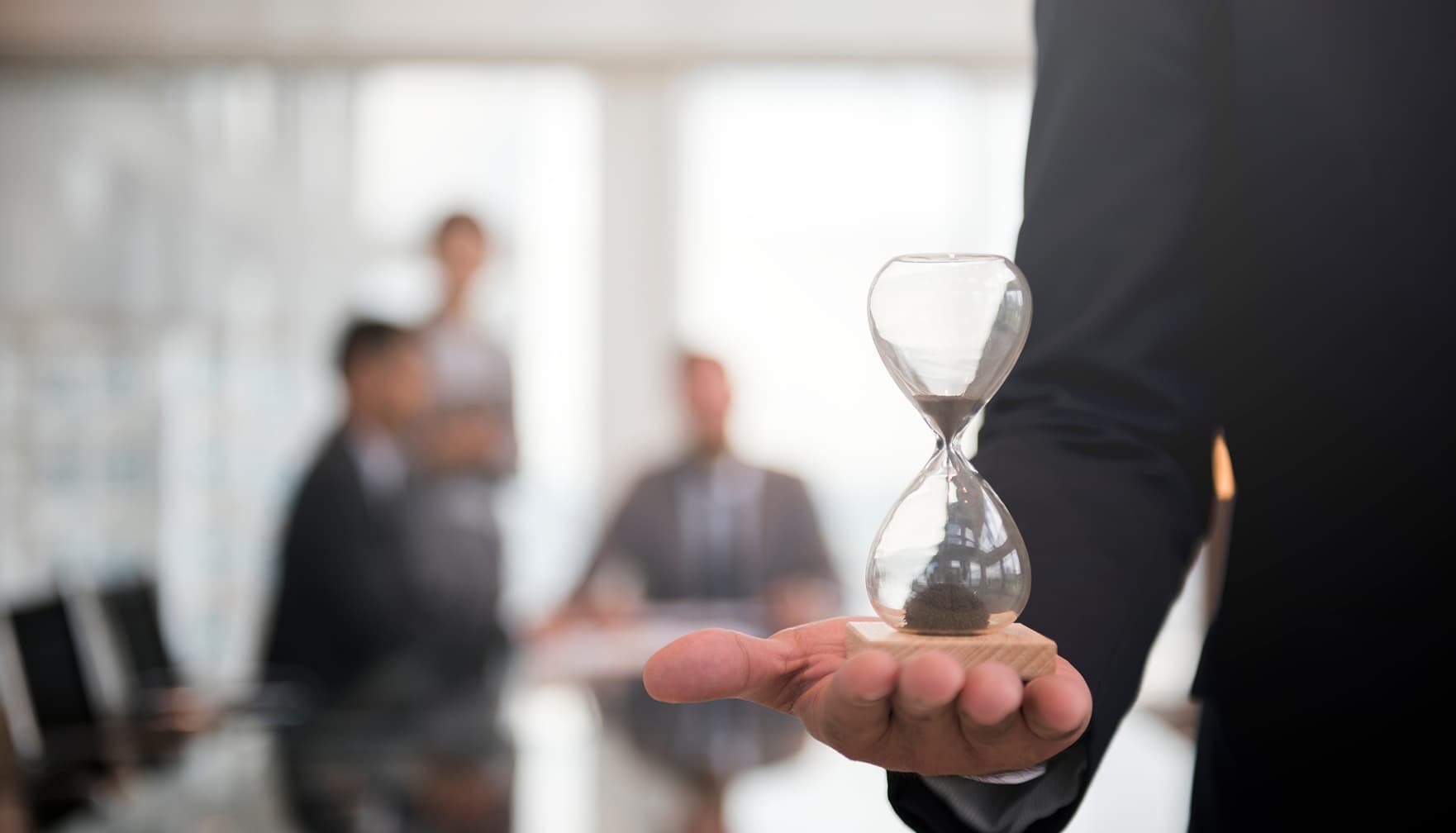 An hourglass held steady in a busy meeting — a methodology that respects your time