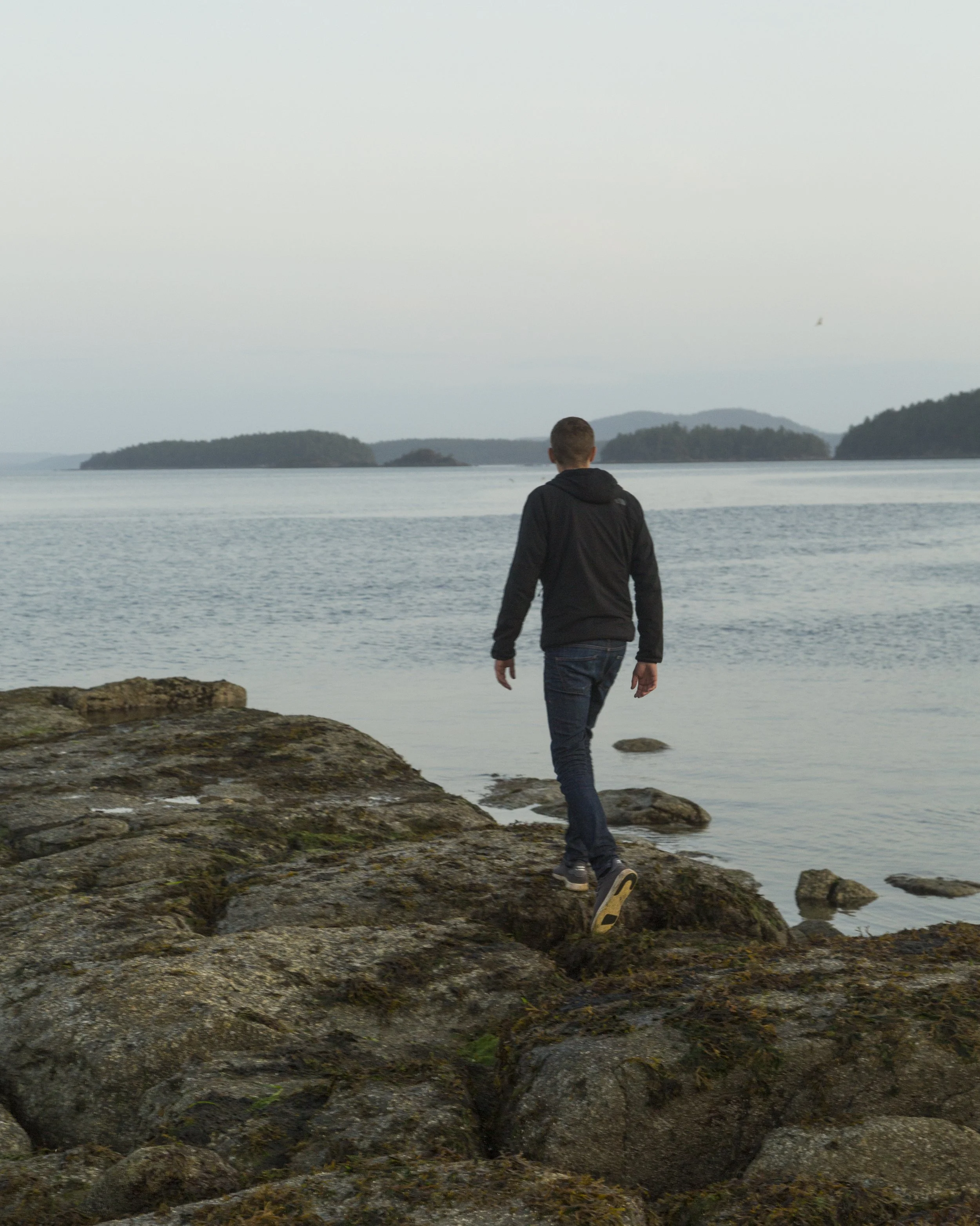 Alex Rumi, Co-Founder of GOOD BUDS walking on Salt Spring Island shoreline