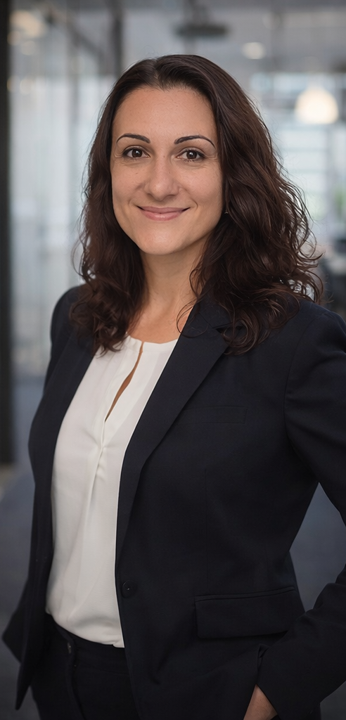 Porträt einer professionellen Frau in formeller Kleidung, lächelnd, im Büro.