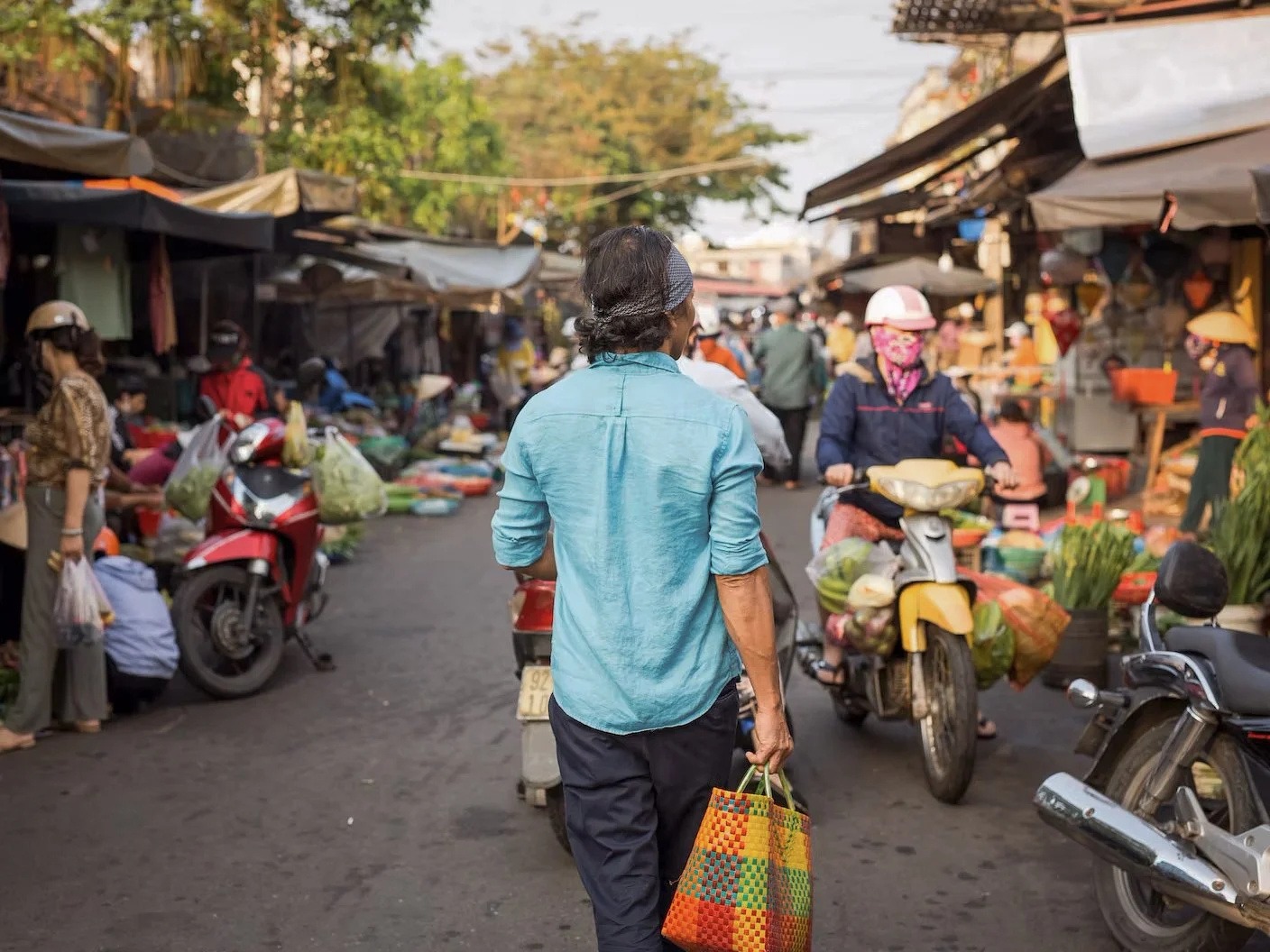 Chef Duc walks through a bustling Hoi An market