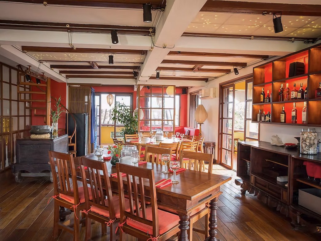 The warm, red-walled dining room at Mango Rooms, overlooking the Thu Bon River
