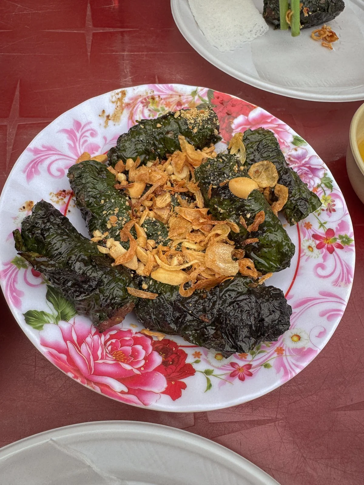 Grilled pork wrapped in betel leaves and topped with crispy fried garlic, a street food specialty of the Vespa tour.