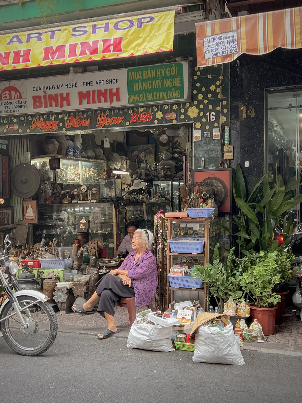 An elderly antique vendor sits outside a shop on Le Cong Kieu Street, Ho Chi Minh City. 