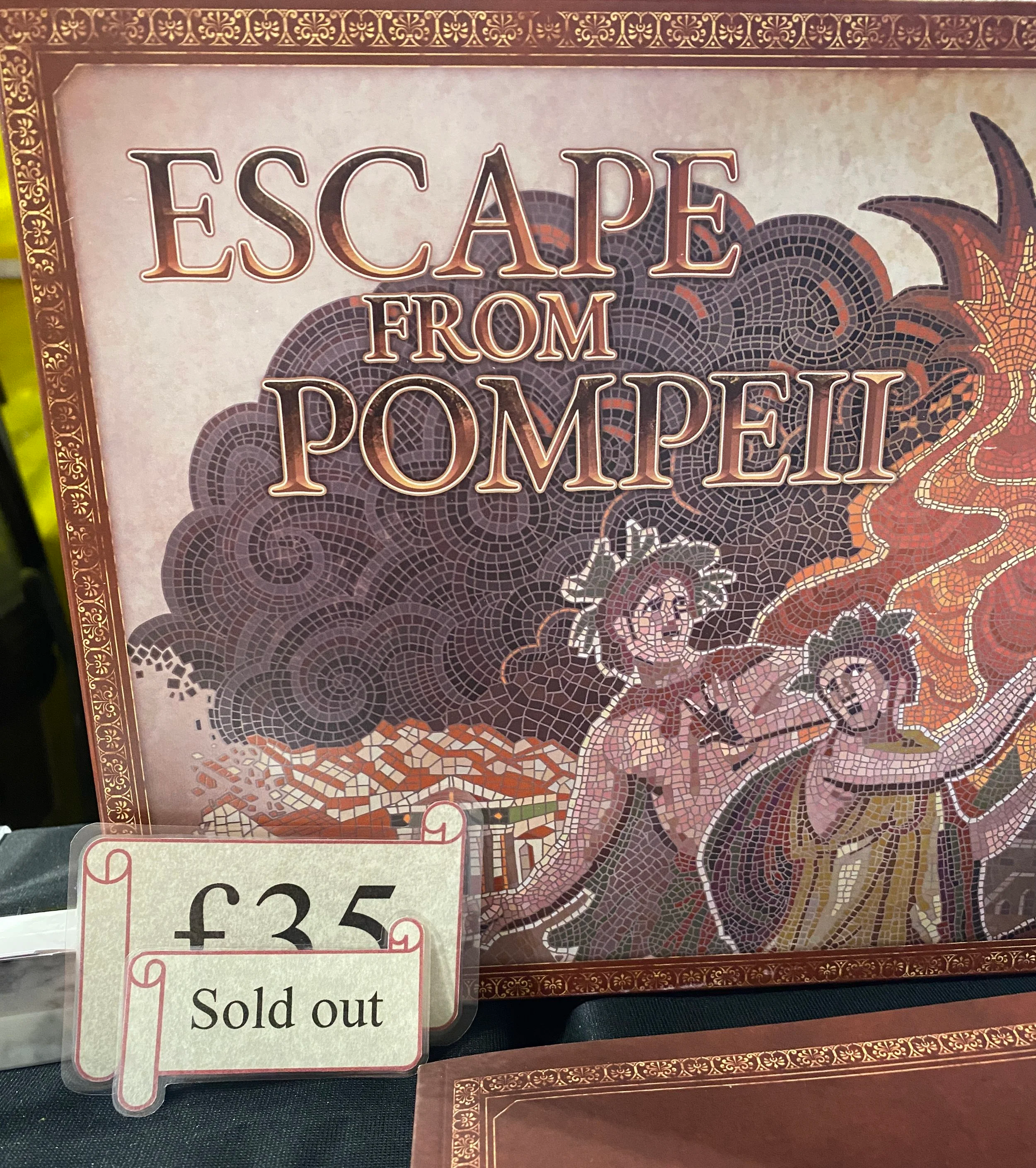 A box of the Escape From Pompeii board game with a sign in front that reads 'sold out'
