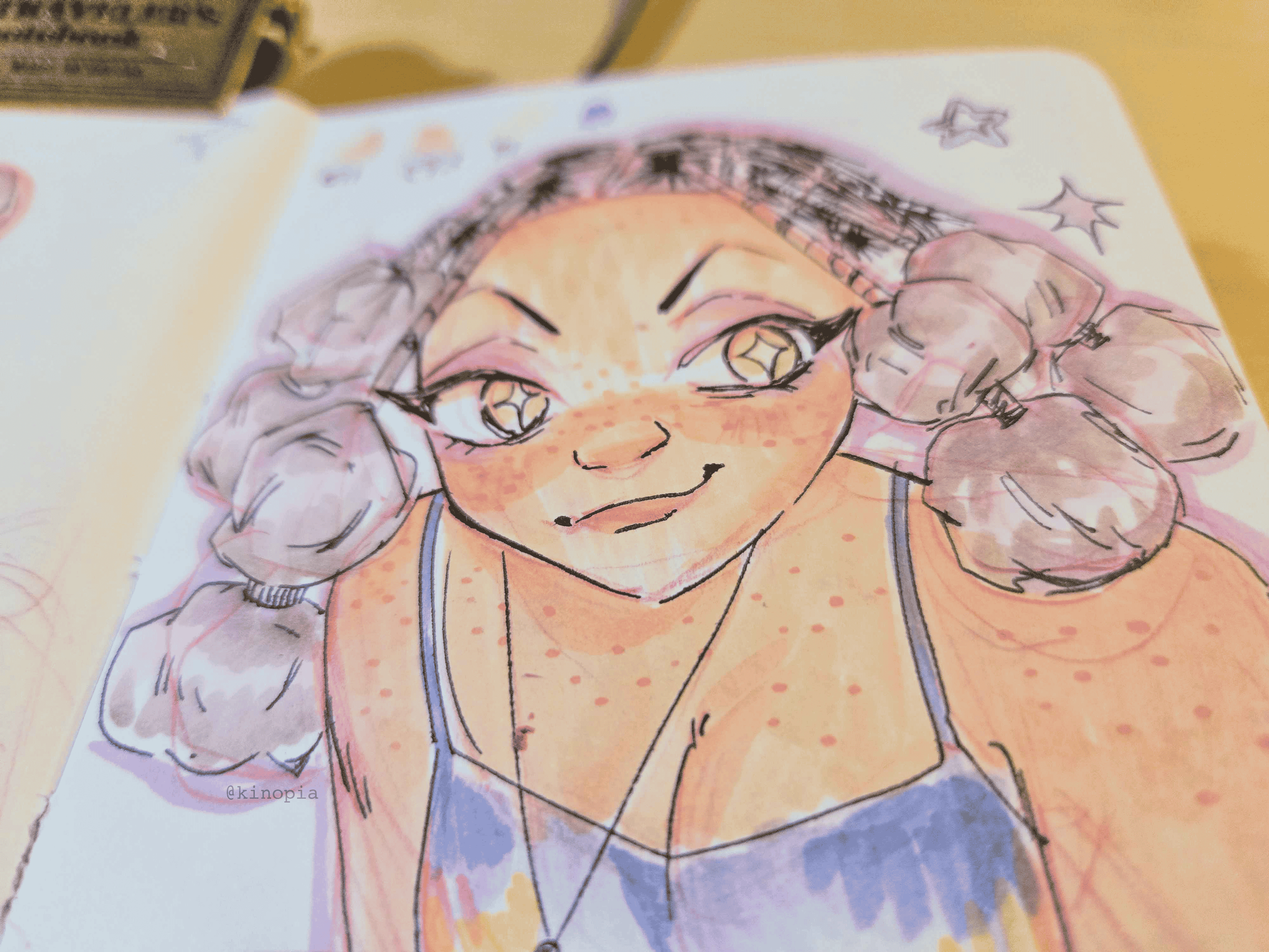 Colorful illustration of a smiling girl with light skin, freckles, big eyes with star-shaped pupils, and curly hair styled in braids. She is wearing a tank top and makes a peace sign with her hand near her face.