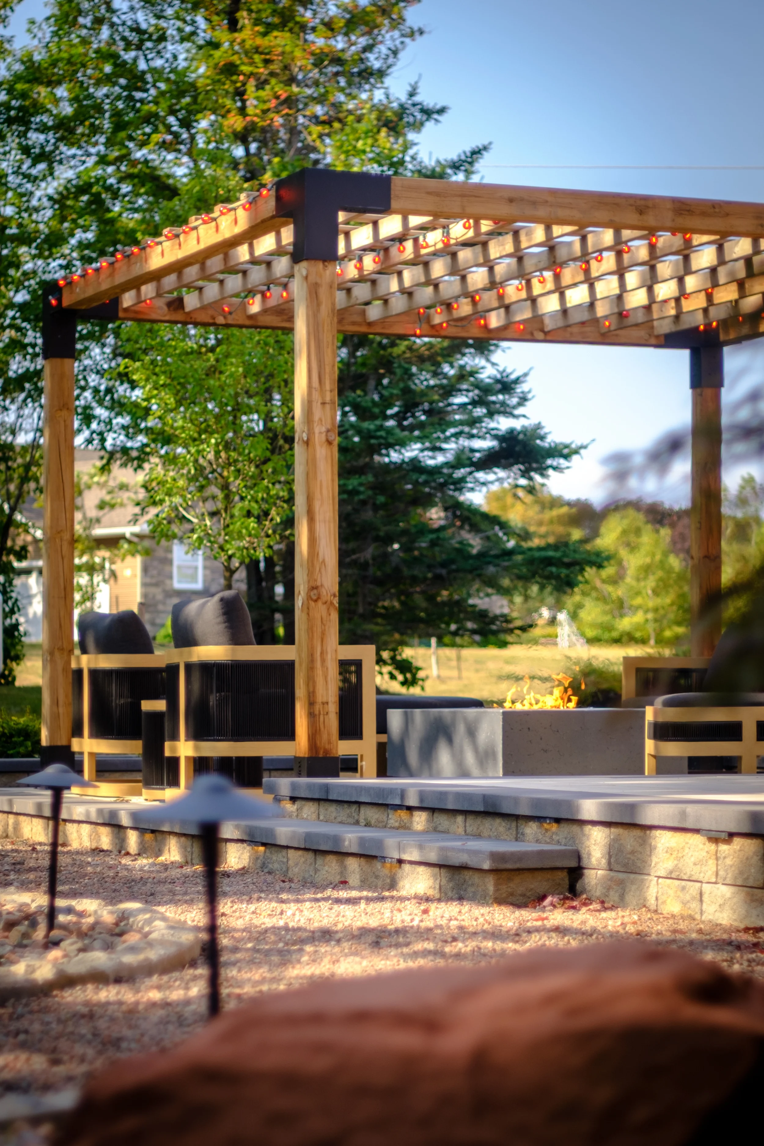 pergola toro brackets string lighting fire table lounge area hardscaping Prince Edward Island