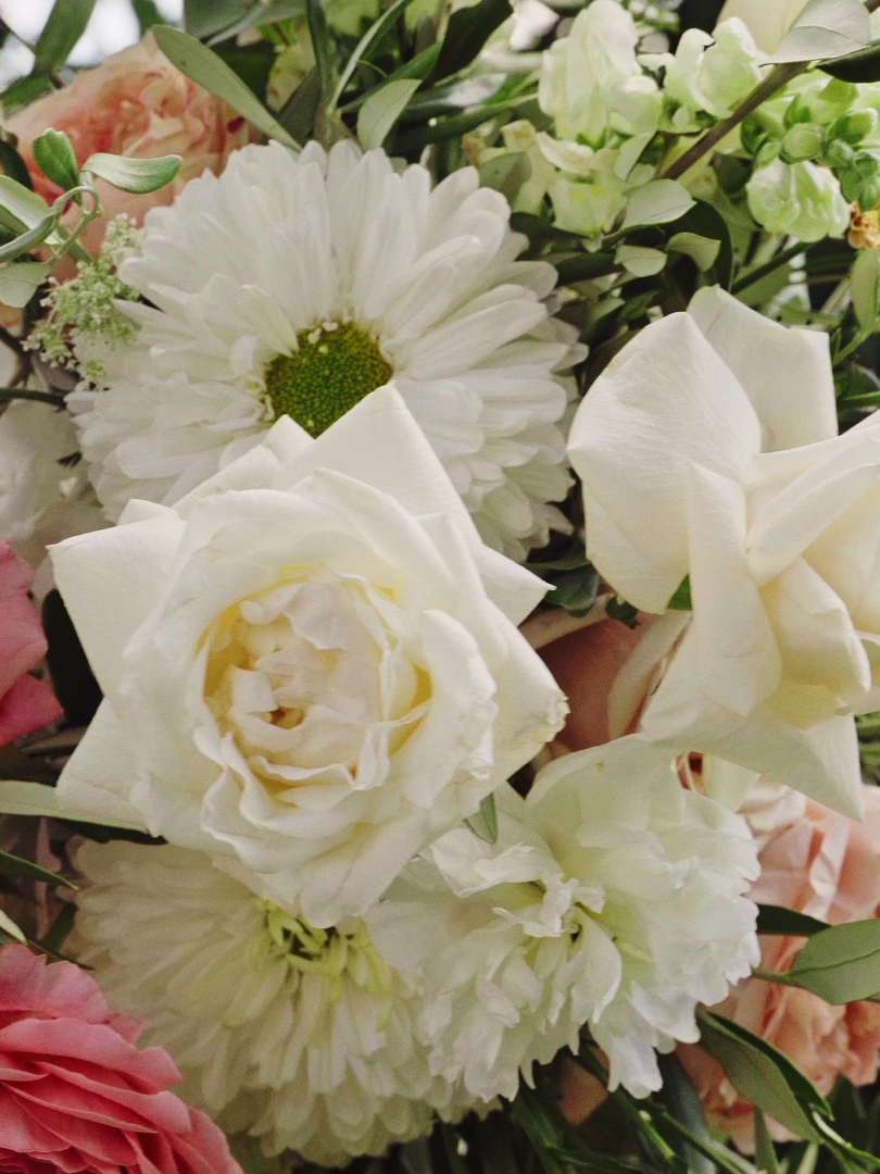Brautstrauß mit weißen Rosen, Chrysanthemen und anderen weißen und pinken Blumen. Ästhetische Moderne Hochzeitsfotos