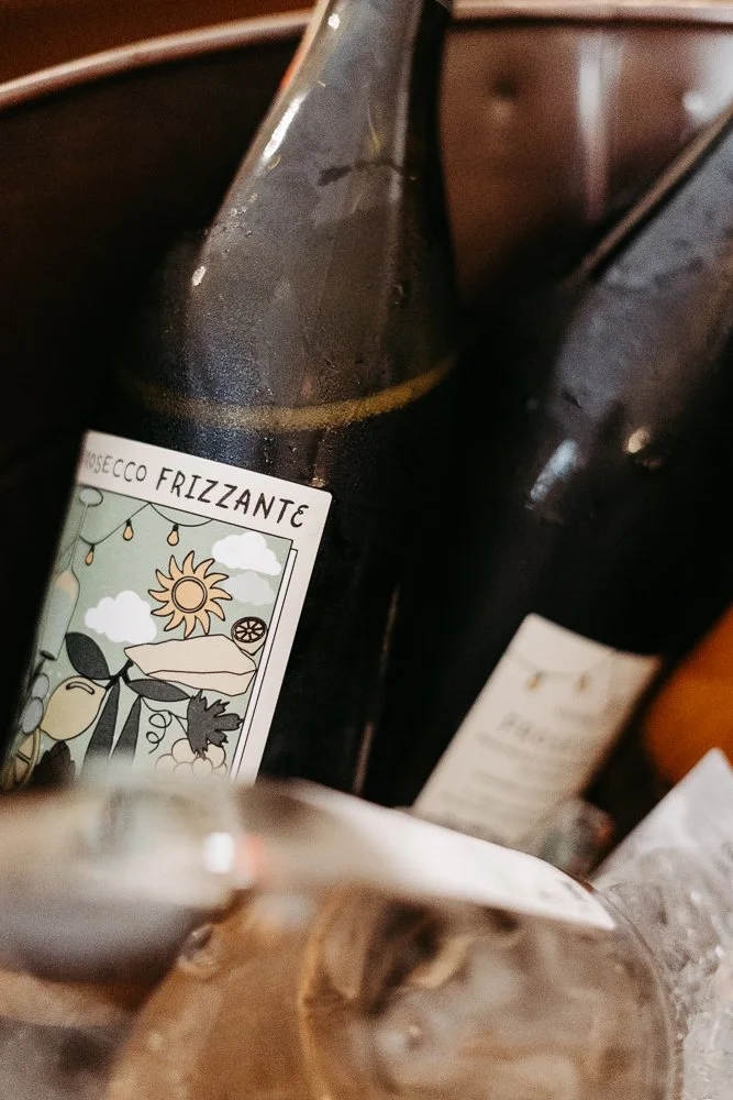 Bottles von erfrischendedem Getränk Mosecco Frizzante, auf einem Tisch mit einem Glas.