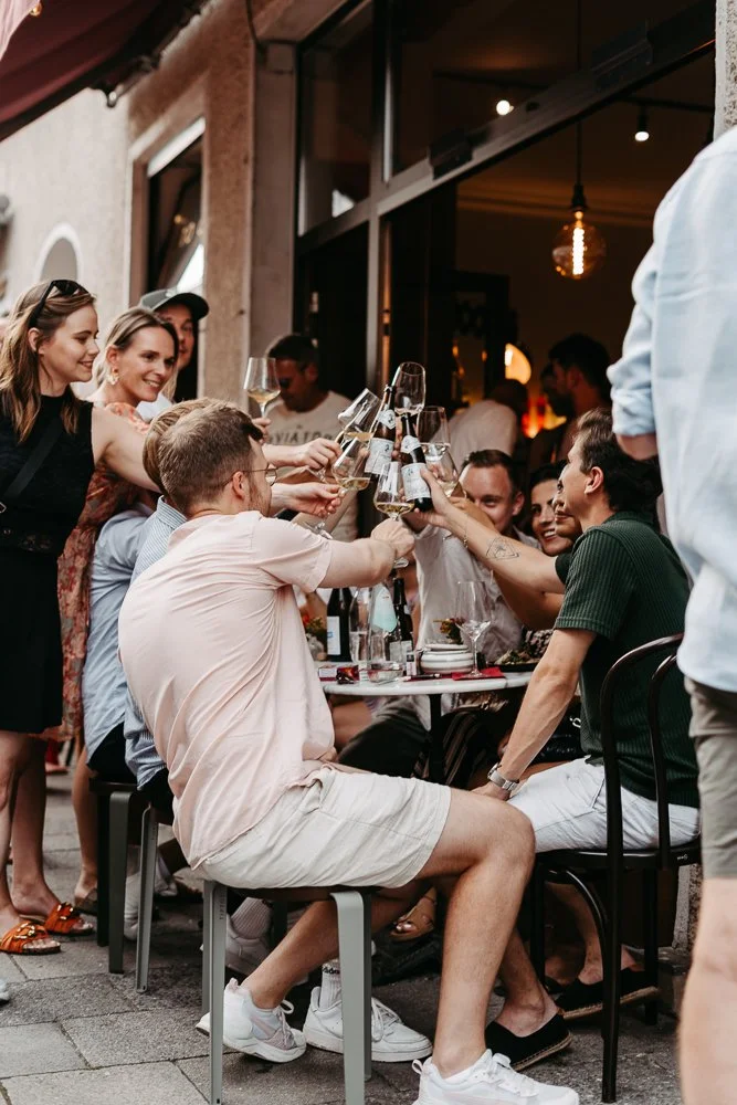 Gruppe von Menschen beim Feiern mit Weingläsern im Restaurant oder Café