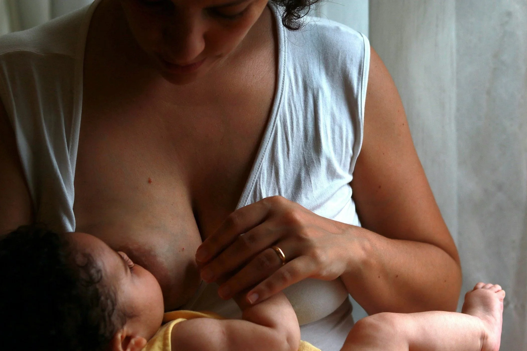 Lactation consultant helping mother improve breastfeeding latch