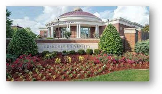 The entrance to TUSKEGEE UNIVERSITY with a landscaped garden in front and a domed building in the background.