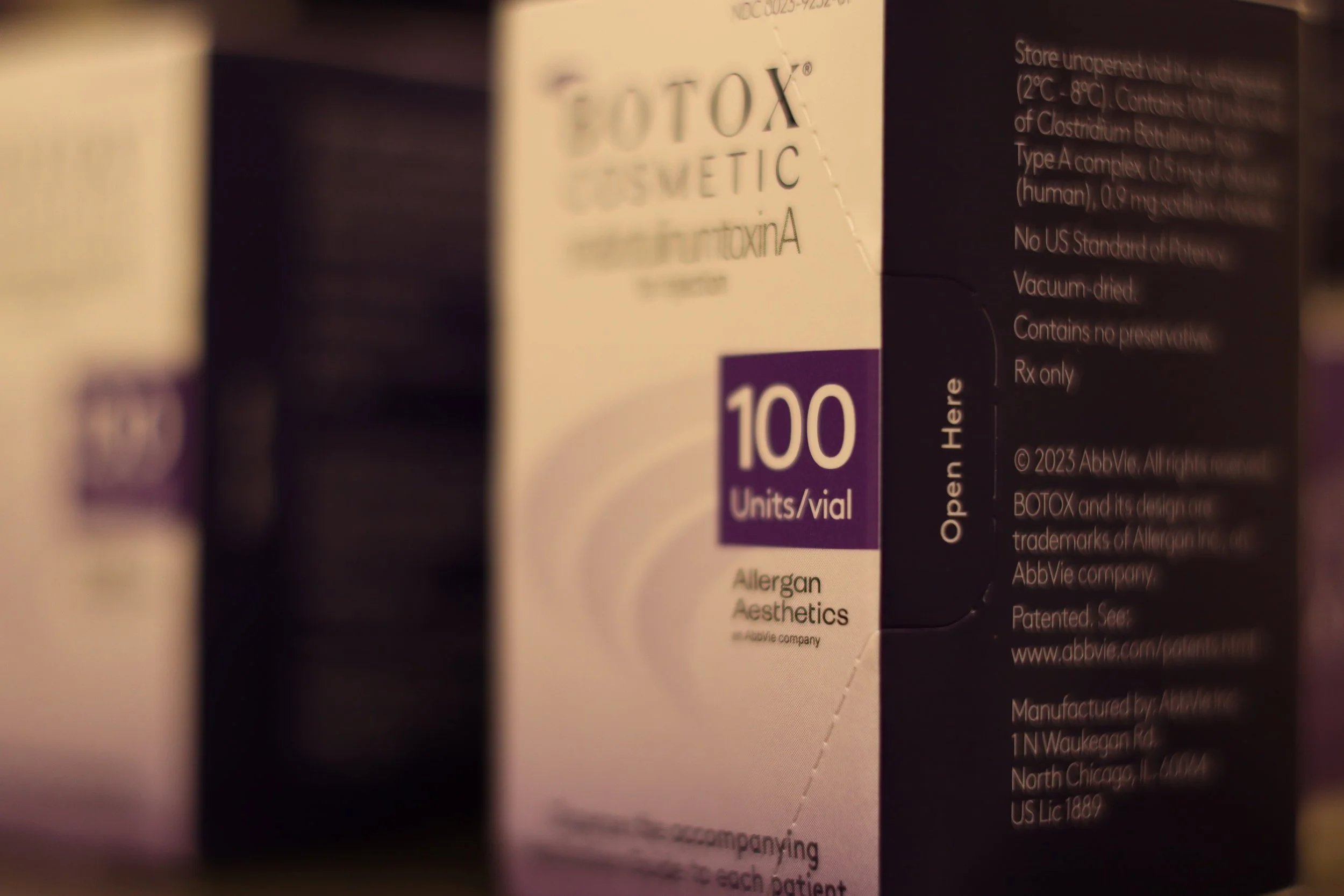 A box of Botox cosmetic has a label indicating 100 units per vial, with the brand Allergan Aesthetics, and instructions to open here.