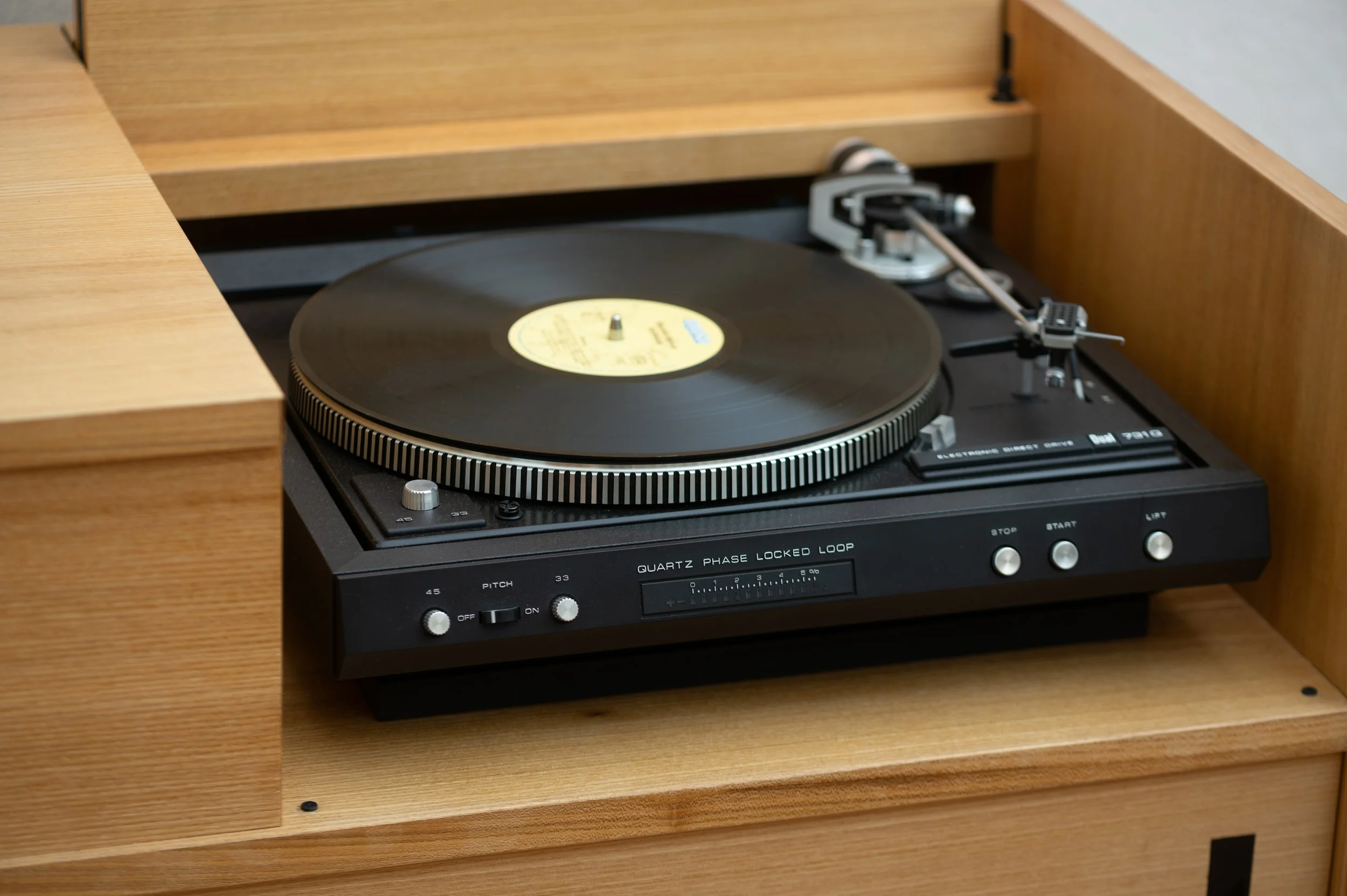 Detailaufnahme eines Dual Plattenspielers im Schallplattenschrank aus Rüster