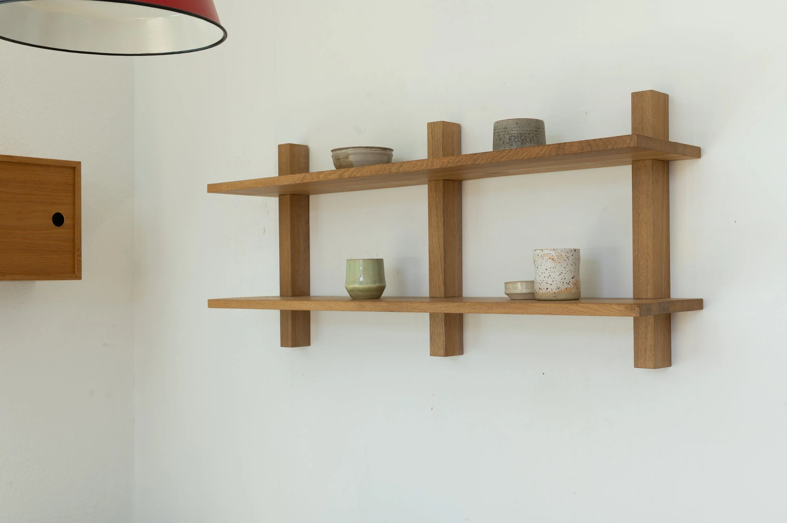 Minimalistisches Wandregal aus Eiche mit Keramikobjekten in neutralen Farben