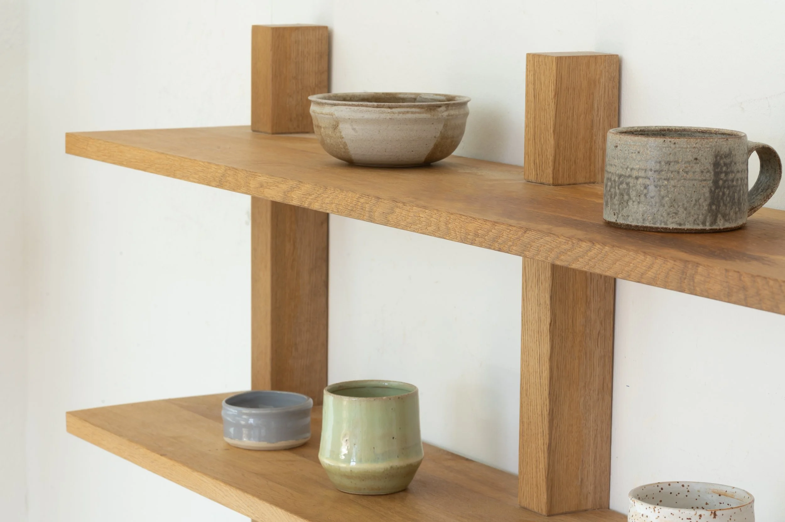 Nahaufnahme von Keramikdeko auf einem Wandregal aus massivem Eichenholz