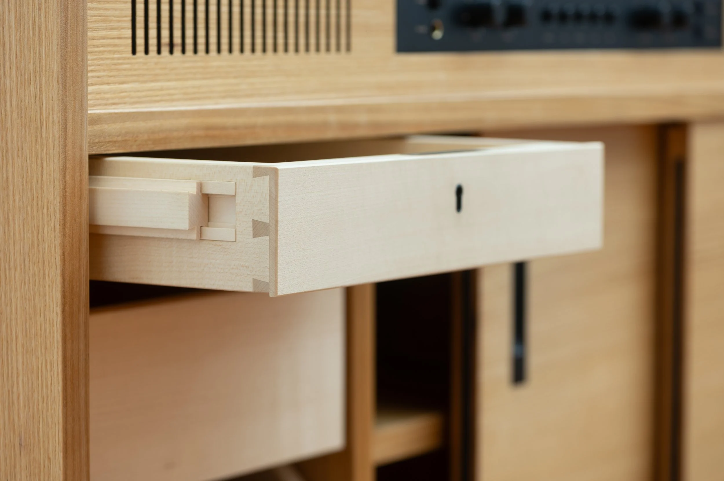 Detailaufnahme eines handgezinkten Schubkastens mit Holzkulissenauszug im Schallplattenschrank aus Rüster