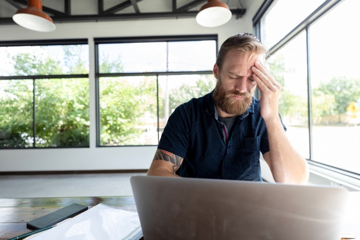 Business owner struggling with overwhelm at his desk